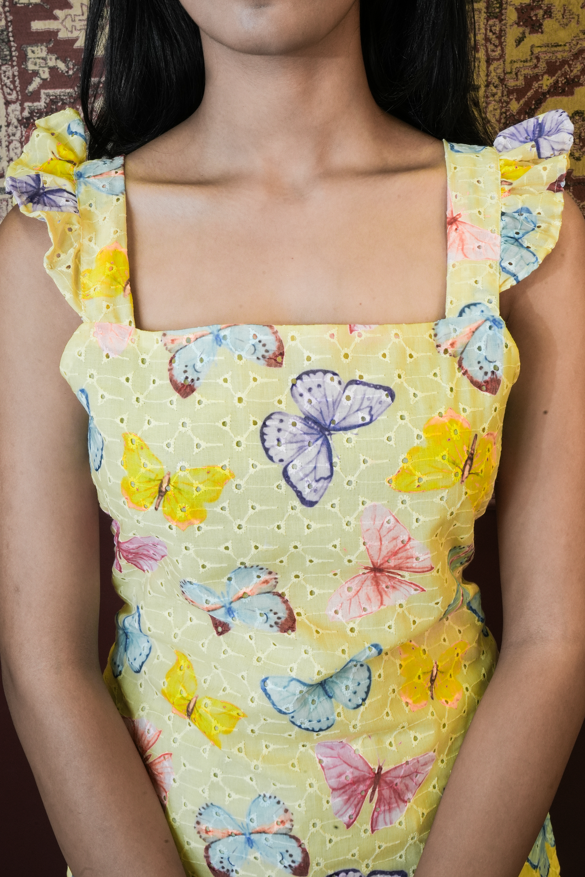 Yellow dress with butterfly pattern worn by a person